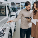 une vendeuse avec son client dans un showroom de voitures