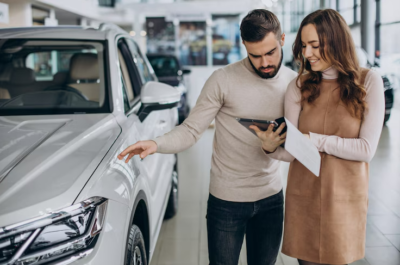 une vendeuse avec son client dans un showroom de voitures