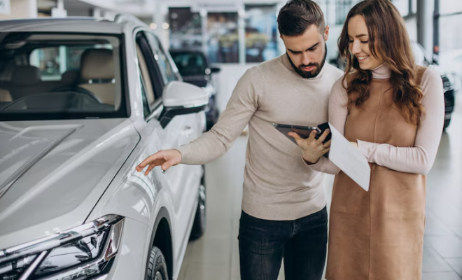 une vendeuse avec son client dans un showroom de voitures